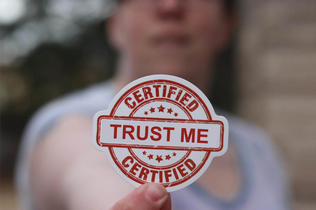 Finger Holding Badge with text certified trust me