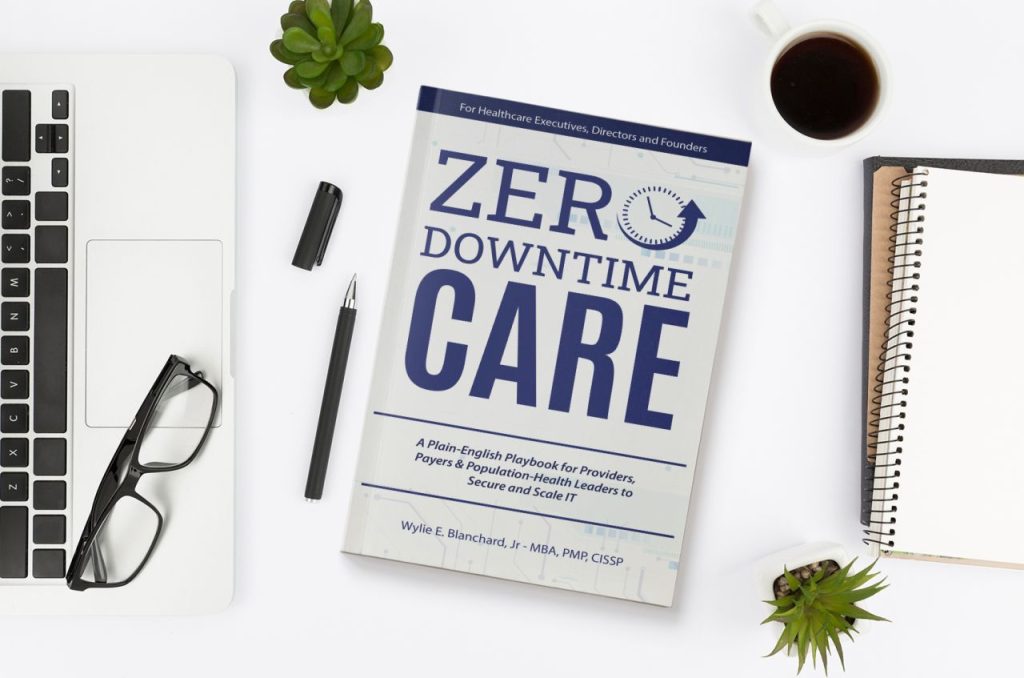 Book on desk next to laptop and notepad. Book cover text: Zero-Downtime Care A Plain-English Playbook for Providers, Payers & Population-Health Leaders to Secure and Scale IT. By Wylie E. Blanchard, Jr
